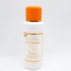 A bottle of lotion with orange cap on top.