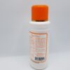 A bottle of lotion with orange cap on it.