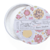 A round container with a lid that has a pattern of flowers on it.