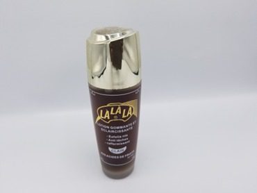 A LALALA LOTION GOMMANTE ET ECLAIRCISSANTE AUX ACIDES DE FRUITS  100ml with a gold lid on a white background.