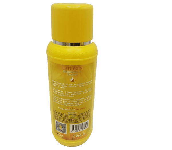 A yellow bottle of Fleur Jaune Body Lotion Soin Blanchissant Traitant 500ml/17oz body lotion with product details in French, displayed against a green background.