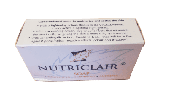 A white box of Nutriclair Lightening Scrubbing Antiseptic Soap 165g featuring text about its moisturizing and antiseptic qualities on a light green background.